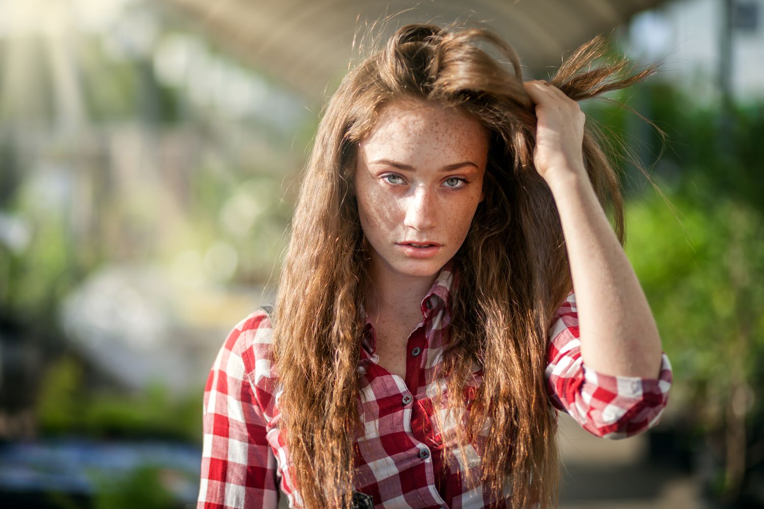 A young woman holding her hair back from her face