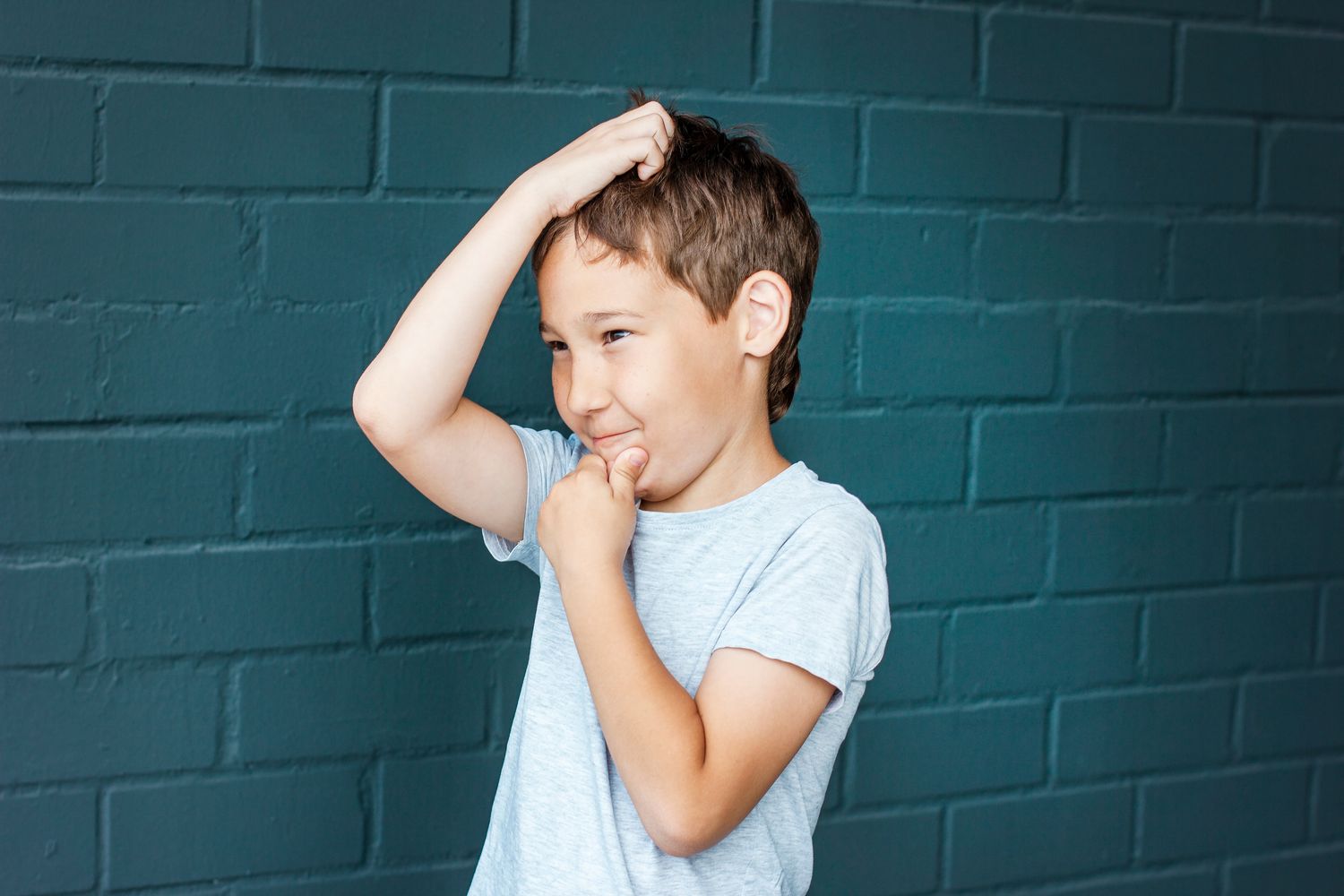 A boy running his fingers through his hair, searching by feel
