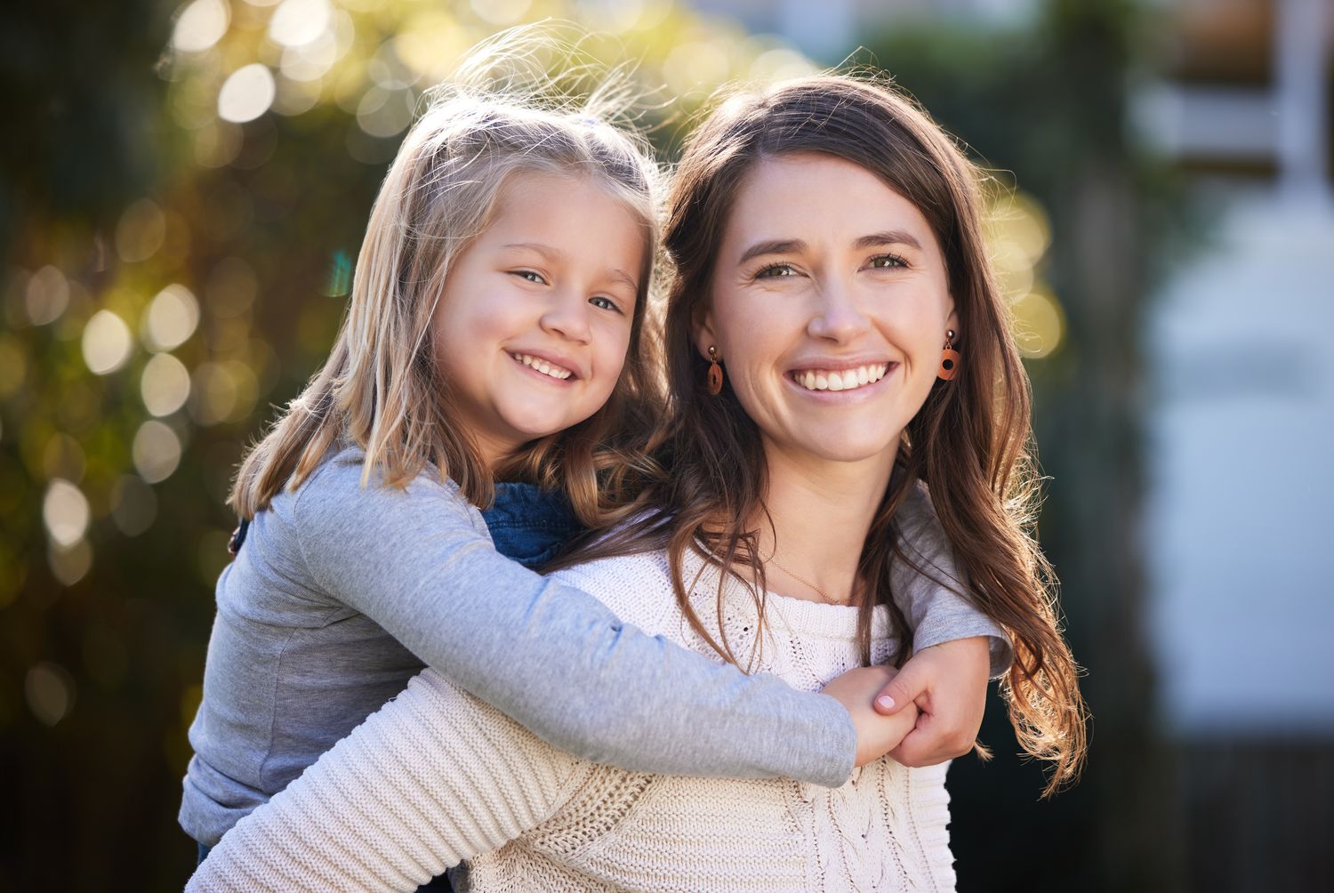 A woman and child smiling together in a garden