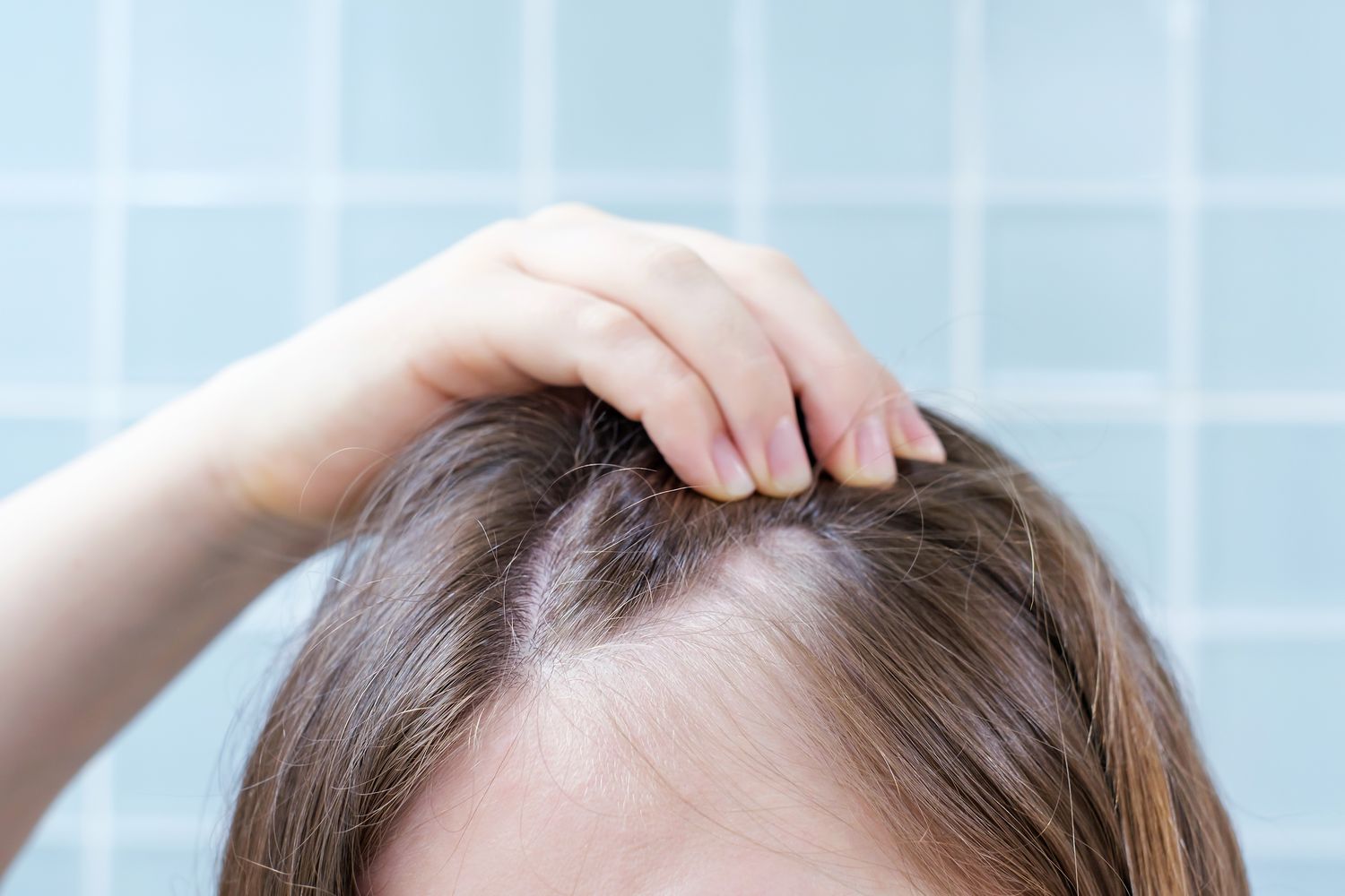 A woman absent-mindedly touching her hair